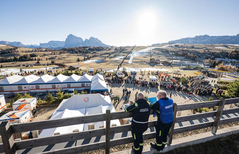 Mastertent Sanitätszelt 8x4m bei Rettungsübung in Seis Große Rettungsübung des Weißen Kreuzes in Seis am Schlern mit weißen, bedruckten Mastertent Sanitätszelten (8x4 m) und Einsatzkräften des Zivilschutzes vor Bergkulisse.